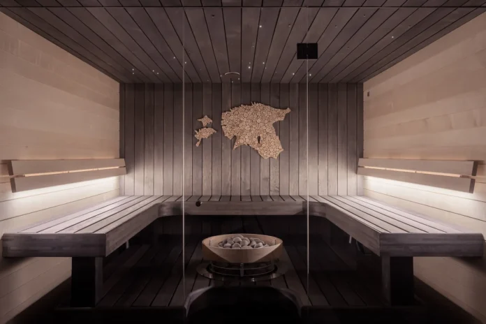 Wood-lined sauna interior with benches and a central heater